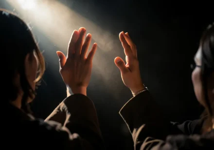 Pessoa adorando a Deus com mãos levantadas em sinal de gratidão.