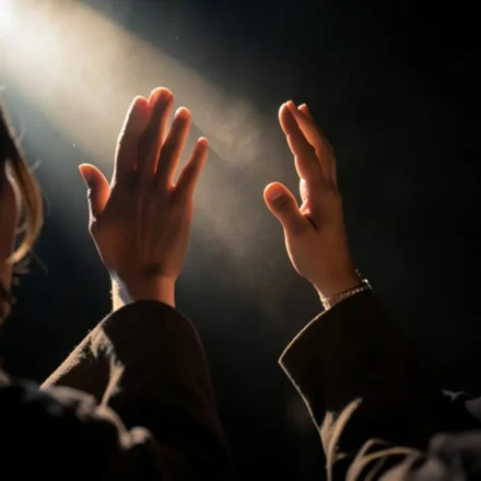 Pessoa adorando a Deus com mãos levantadas em sinal de gratidão.