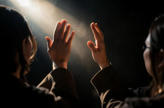 Pessoa adorando a Deus com mãos levantadas em sinal de gratidão.