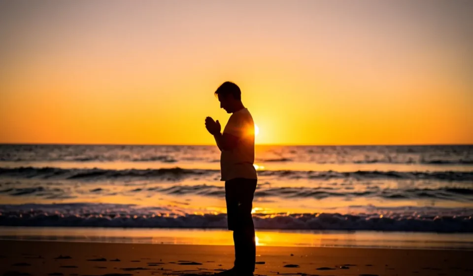 Pessoa orando ao nascer do sol representando a nova vida cristã após o batismo.
